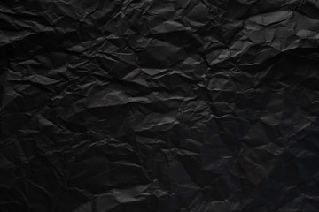 Black crumpled paper texture background.