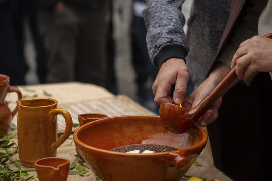 A man is preparing queimada (traditional Galician hot drink made with flamed "orujo", sugar and lemon)