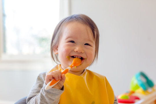 Happy toddler boy smiling while eating a meal