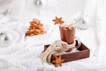 Cup of hot chocolate with marshmallow and gingerbread cookies on tray