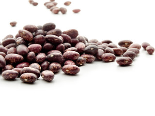 puñado de alubias rojas pintas vistas sobre un fondo blanco