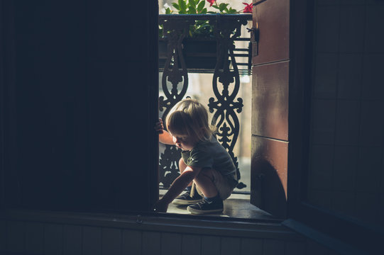 Little toddler playing on the balcony