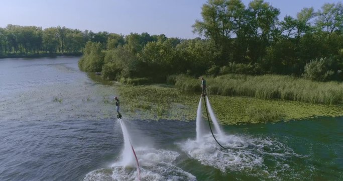 Flyboarders doing tricks Aerial flying Flyboard wide shot view from above. Flyboarding 4K video