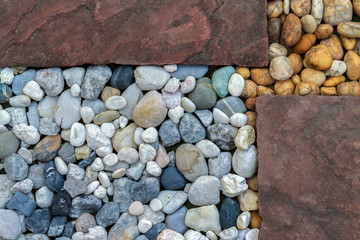 Background of textured from natural multicolor pebbles and old red sandstone in the gardens