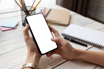 hand woman using a telephone, empty screen smart phone and computer on wooden table In home office....