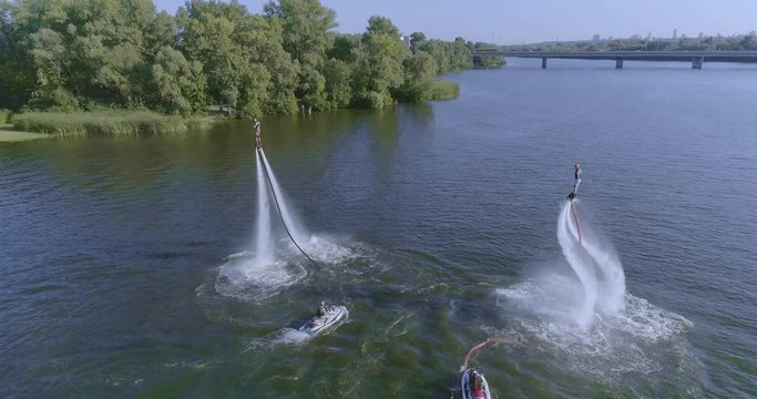 Flyboarders doing tricks Aerial flying Flyboard wide shot view from above. Flyboarding 4K video