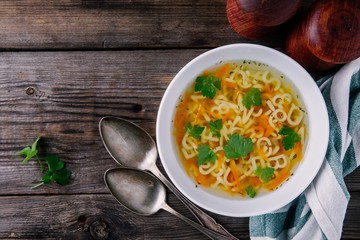 Homemade Chicken and Alphabet Soup with carrots and parsley in bowl