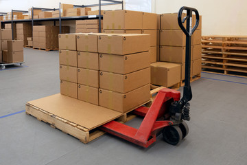 Pallet Jack with full of cartons at logistics warehouse