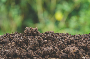 Preparing soil for agriculture and Pile of soil with green background.