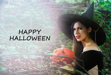 Young pretty woman in witch's hat holding halloween pumpkin jack