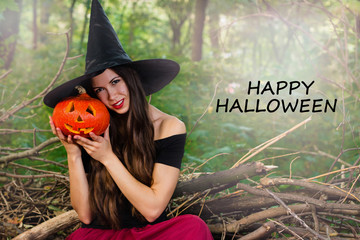 Young pretty woman in witch's hat holding halloween pumpkin jack