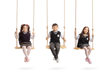 Schoolchildren sitting on wooden swings