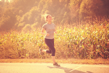 woman jogging along a country road
