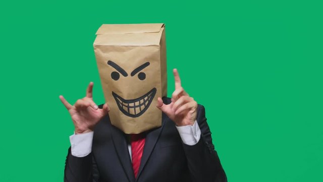 concept of emotion, gestures. a man with a package on his head, with a painted smiley angry, sly, gloating