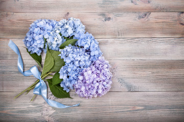 branches of blue hydrangea on wooden background