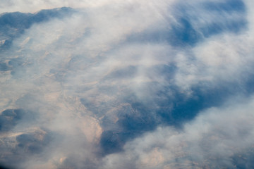 Aerial view of Sierra Nevada mountains filled with fire smoke. California at sunrise shot from an airliner