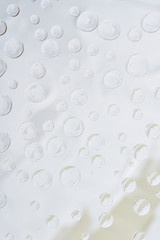 close-up view of transparent water drops on light abstract background
