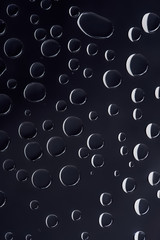 close-up view of transparent water drops on black abstract background