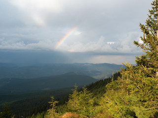 Rainbow above the mountain range. Carpathians mountains at summer, west Ukraine. Tops of firs...