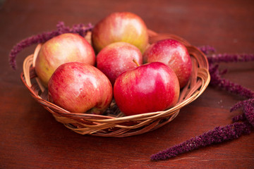 Apples in a basket on a wooden table
