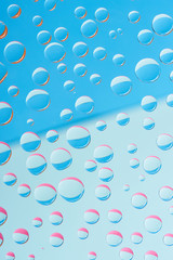 close-up view of transparent dew drops on blue abstract background