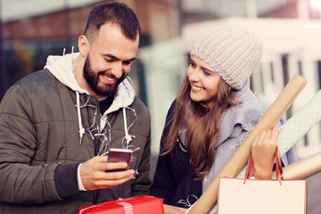 Obraz premium Portrait of happy couple with shopping bags after shopping in city