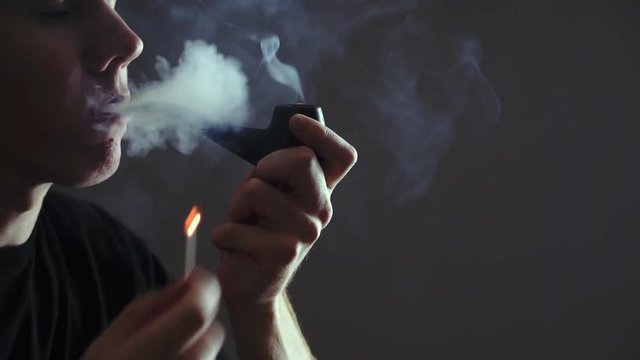 man lights Smoking pipe
