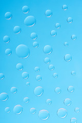 close-up view of transparent water drops on blue background