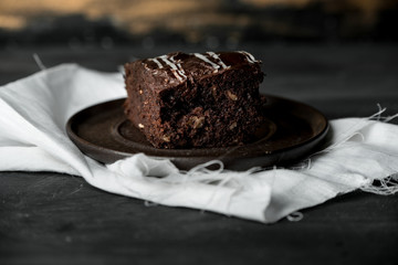 sweet chocolate brownie with coffe cream on a dark, rustic, wooden table