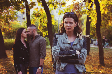 relationship concept tree people arguing  outdoor in park problems, secret behind back 