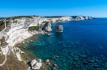 Panoramic view of the Cliffs of Bonifacio and the Grain de Sable in the south of Corsica, overlooking a calm blue mediterranean sea under blue sky on a clear sunny day.