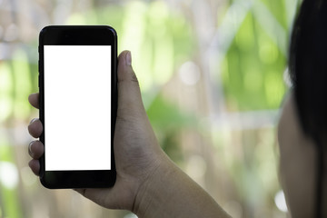 women hand holding black mobile phone with blank white screen on the outdoor background.