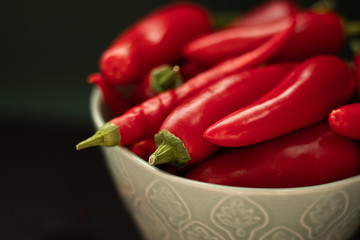 Red chili pepper in a bowl on a dark background