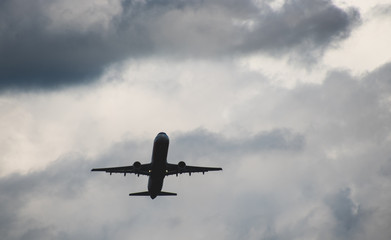 Silhouette of a plane taking off against the blue sky