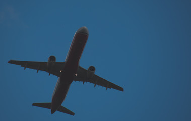 Silhouette of a plane taking off against the blue sky