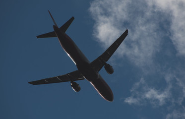 Silhouette of a plane taking off against the blue sky