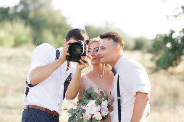 wedding photographer takes pictures of bride and groom - obrazy, fototapety, plakaty