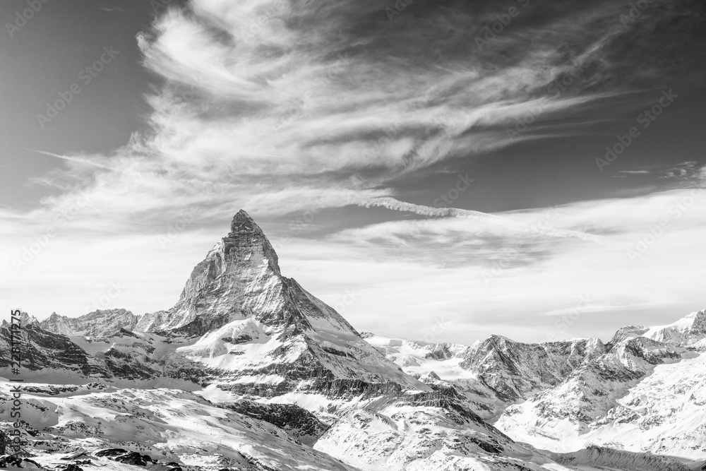 Wall mural monochrome view on snowy matterhorn and other mountains with dramatic sky with clouds, switzerland