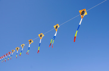 big colorful kite flies high in the sky . Beautiful kites in a kite festival