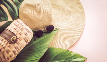 Still life with a beach hat on a pink background