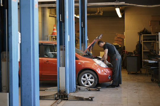 Specialist auto mechanic in the car service, checks the car, engine, engine, carburetor. Concept: repair of machines, fault diagnosis, repair specialist, technical maintenance and on-board computer.