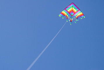 big colorful kite flies high in the sky . Beautiful kites in a kite festival