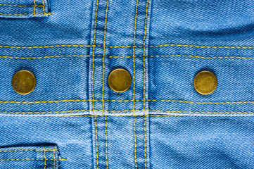 Blue washed faded jeans texture with seams, clasps, buttons and rivets