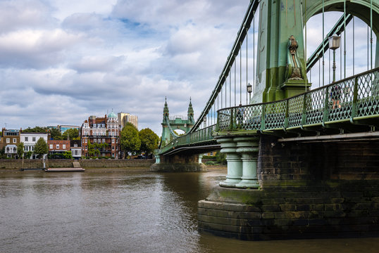 The Hammersmith Bridge, a suspension bridge that crosses the River Thames in west London. Hammersmith is in the background, photo taken from Barnes.