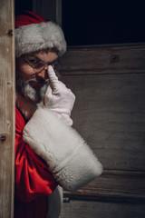 Weihnachtsmann schleicht sich durch die Türe