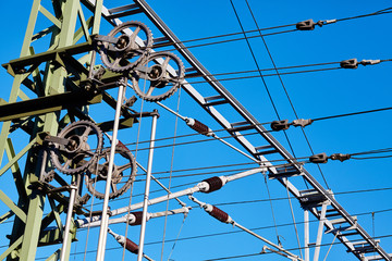 Overhead train electric traction system against the blue sky.