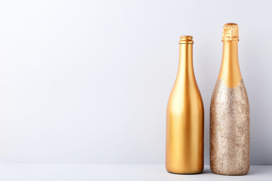 Decorated champagne bottles on grey background