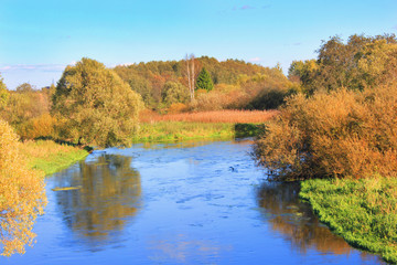 Autumn Nature with Colorful Trees and River VIew at Countryside Park. Autumn Scenery and Fall Seasonal Background with Green, Orange and Yellow Color Leaves. Outdoor Wallpaper of Autumn Landscape