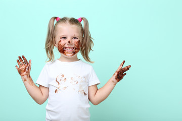 Happy little girl in chocolate on mint background