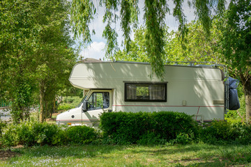 Motorhome parqueada entre árvores no meio da natureza.